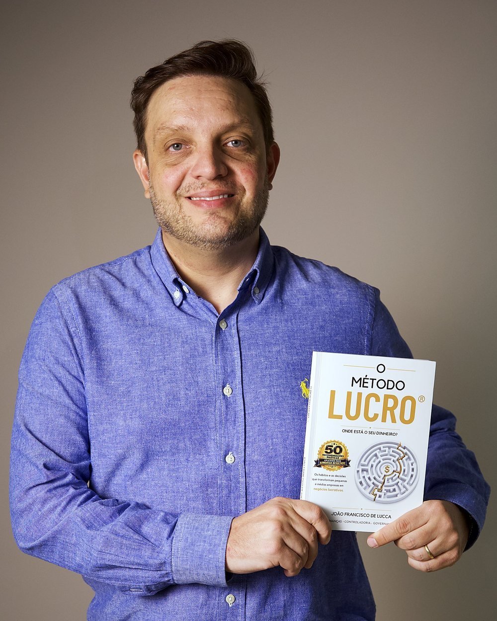 João Francisco De Lucca segurando o livro O Método LUCRO®
